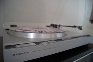 Une platine sur laquelle se trouve un disque rose et noir